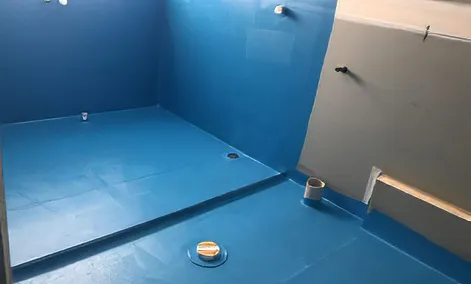 Licensed professional applying waterproofing membrane to floor and walls before tiling during a Ryde renovation.