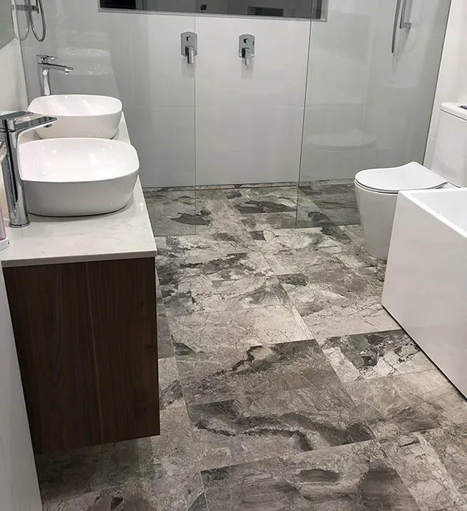 Modern bathroom with double vessel sinks, frameless glass shower, freestanding rectangular bathtub, and polished stone-look floor tiles for a clean, luxurious finish.