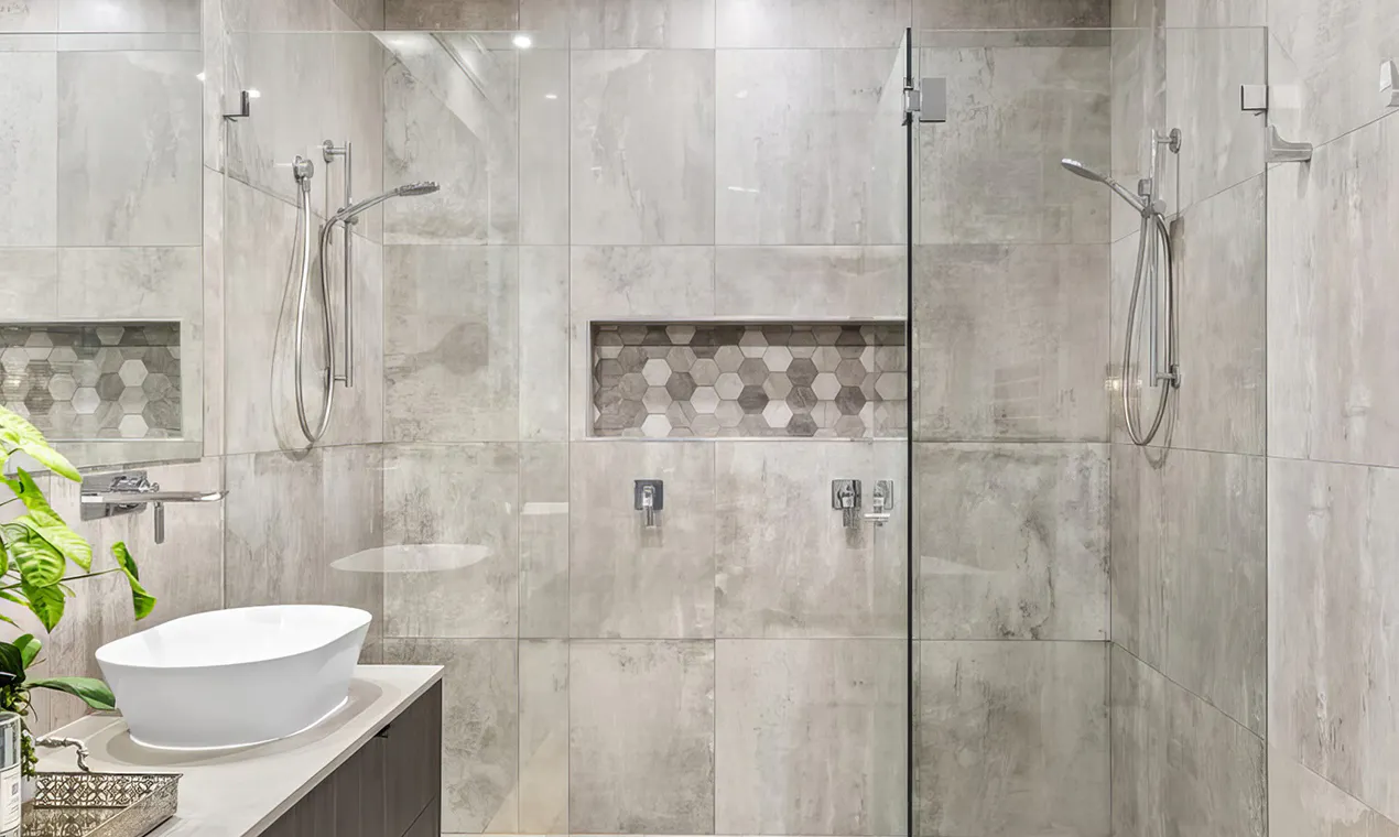 Hero image for Bathroom Renovations Beecroft featuring a modern double shower with frameless glass, grey stone-look tiles, hexagonal mosaic niches, and sleek vanity with white countertop basin.