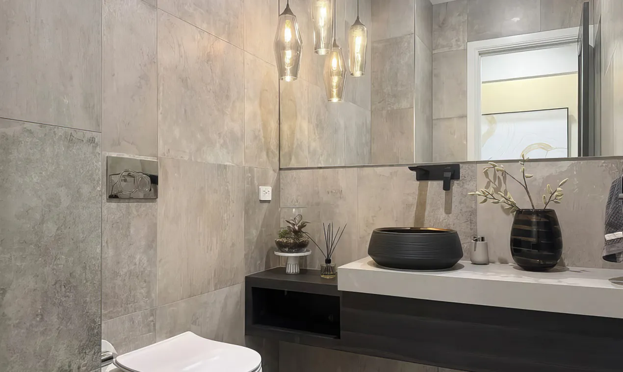 Elegant modern bathroom in Beaumont Hills featuring a black vessel basin, wall-mounted tapware, stone-look tiles, pendant lighting, and a floating vanity for a contemporary finish.